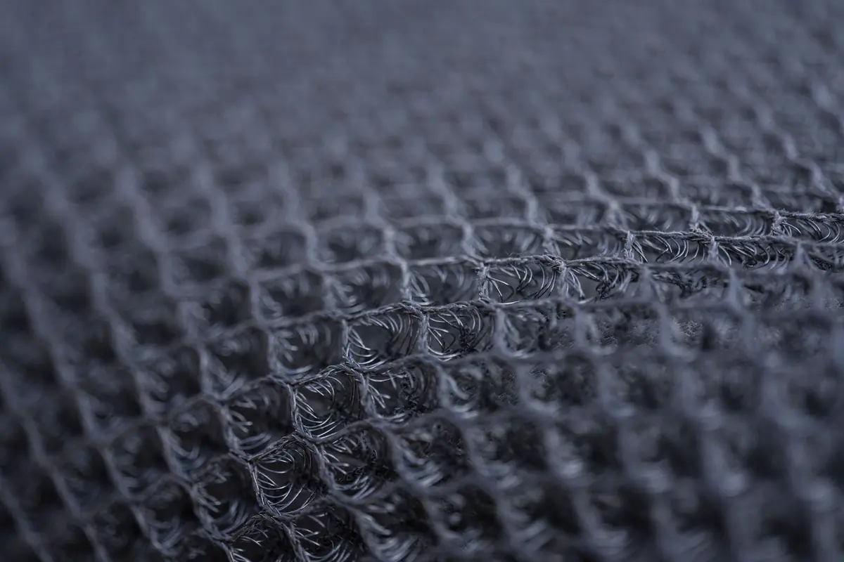 Extreme close-up of a dark woven fabric, every thread of the weave visible