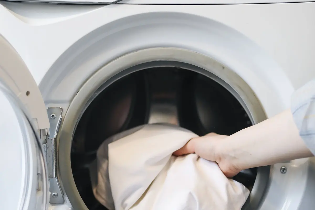Clothes spill out of the open door of a front-loading washing machine