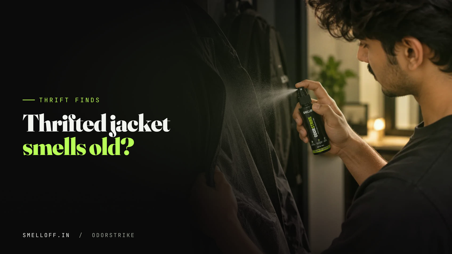 A fabric spray is misted inside the lining of a black jacket hanging on a hook